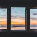 white wooden framed glass window near body of water