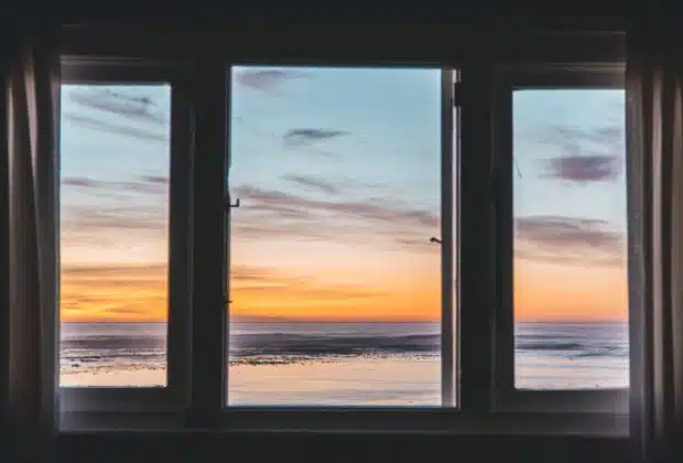 white wooden framed glass window near body of water
