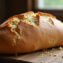 Pain maison doré avec croûte croustillante sur surface en bois