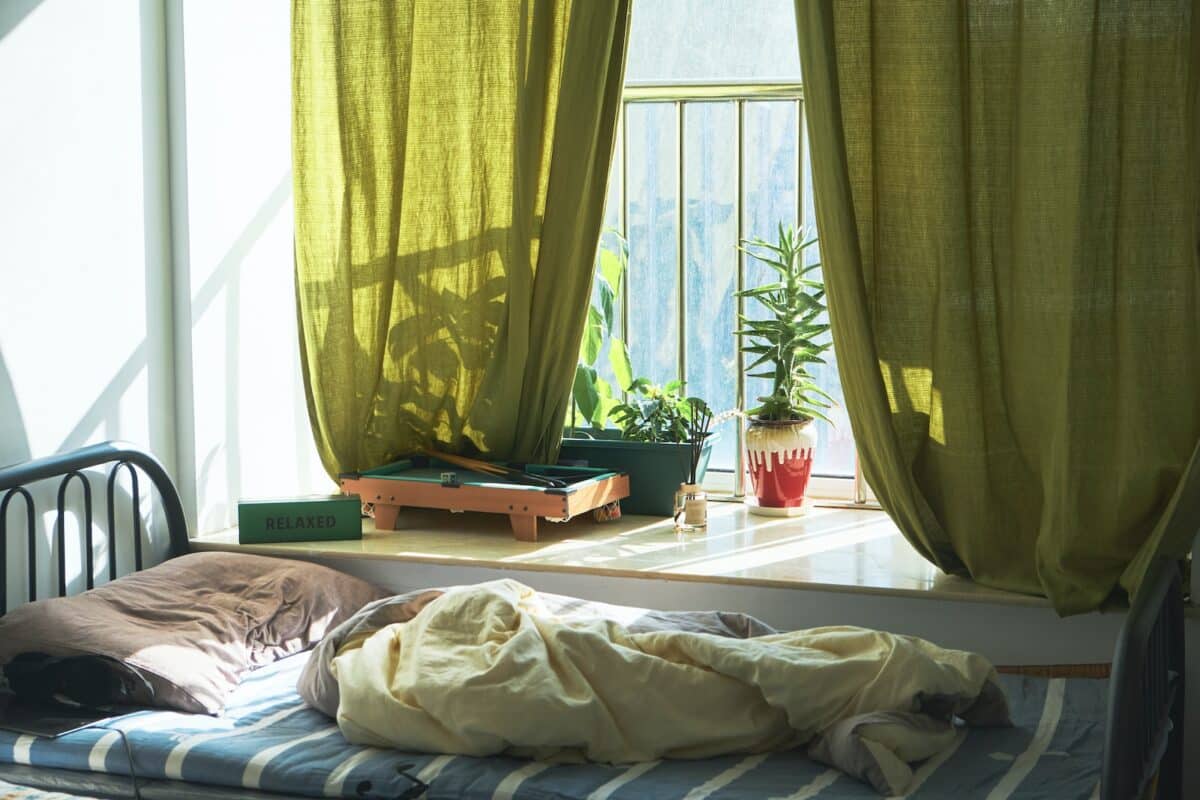 a bed sitting in a bedroom next to a window